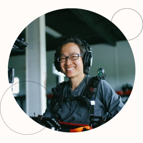 East Asian woman wearing headphones and glasses