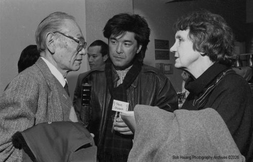 1980s black and white photo showing an older Asian man, a middle aged Asian man, and white woman